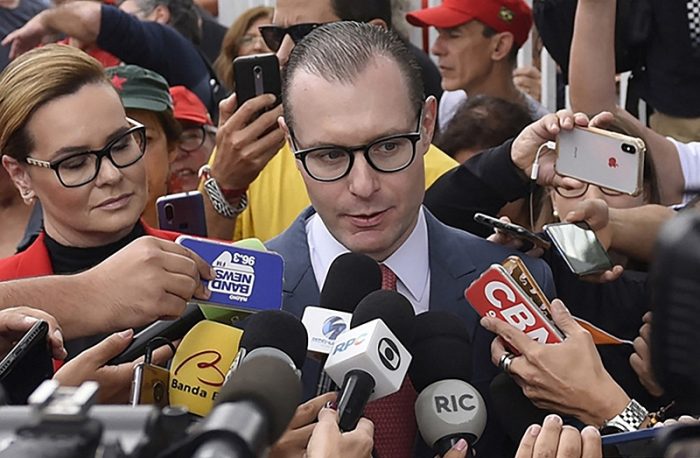 Cristiano Zanin (C) and Valeska Teixeira Zanin Martins, lawyers of former Brazilian President Luiz Inacio Lula da Silva, speak to the press after visiting the ex-president at the Federal Police Headquarters in Curitiba, Parana State, Brazil, on November 8, 2019, a day after the Supreme Court issued a ruling that could see the ex-president free. Brazil's Supreme Court voted on November 7, to overturn a ruling requiring convicted criminals to go to jail after losing their first appeal, paving the way for leftist icon Lula da Silva to be freed. (Photo by HENRY MILLEO / AFP)