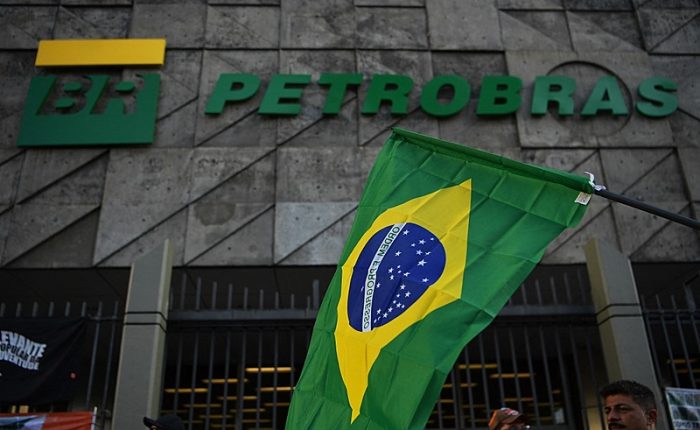 (FILES) In this file photo taken on February 18, 2020 a Brazilian flag is seen during a protest against layoffs outside Brazil's state-owned oil company Petrobras headquarters in Rio de Janeiro, Brazil. - Virtually headless for over a week, Brazil´s oil giant Petrobras goes through a moment of uncertainty after the scandal of the Lava Jato (Car Wash) investigation against corruption. (Photo by CARL DE SOUZA / AFP)